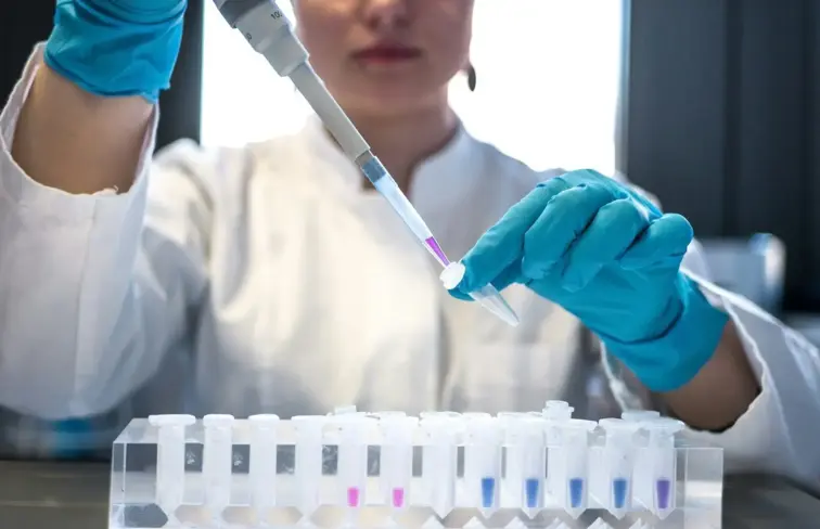 Imagem de técnica em laboratório a mexer em tubos